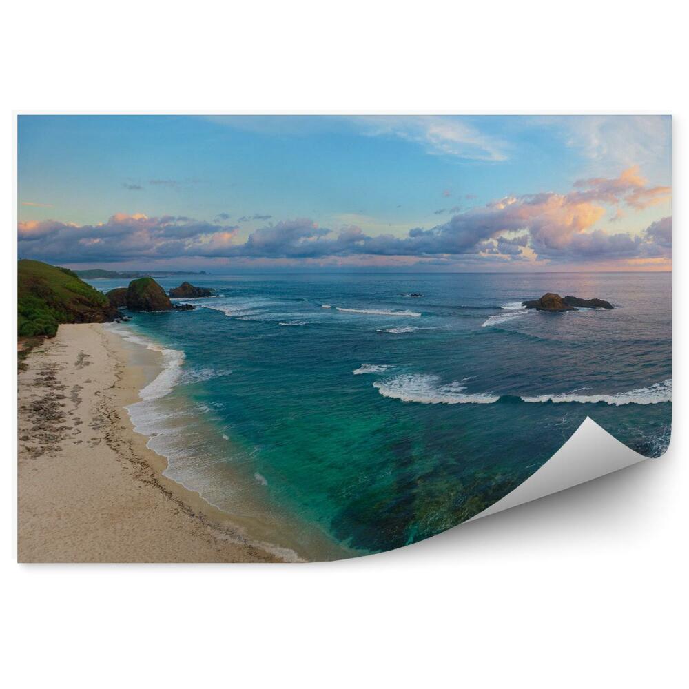 Fototapeta Panoramiczny widok tropikalnej plaży z surferów o zachodzie słońca.