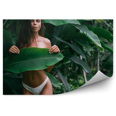 Fotopeta Brunetka zasłonięta dużym liściem natura