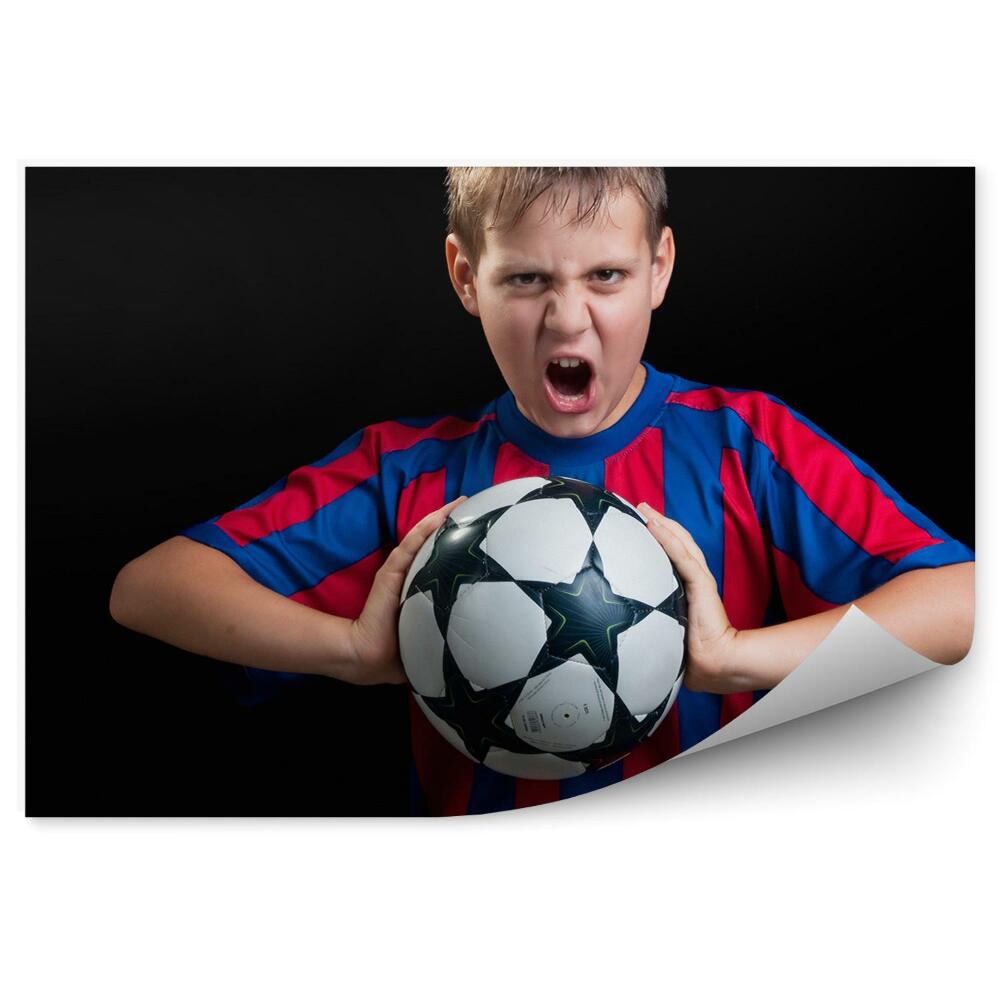 Fototapeta na ścianę Chłopiec trzymający piłkę nożną
