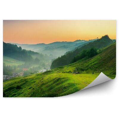 Okleina na ścianę Wschód słońca góry drzewa trawa stok wieś mgła