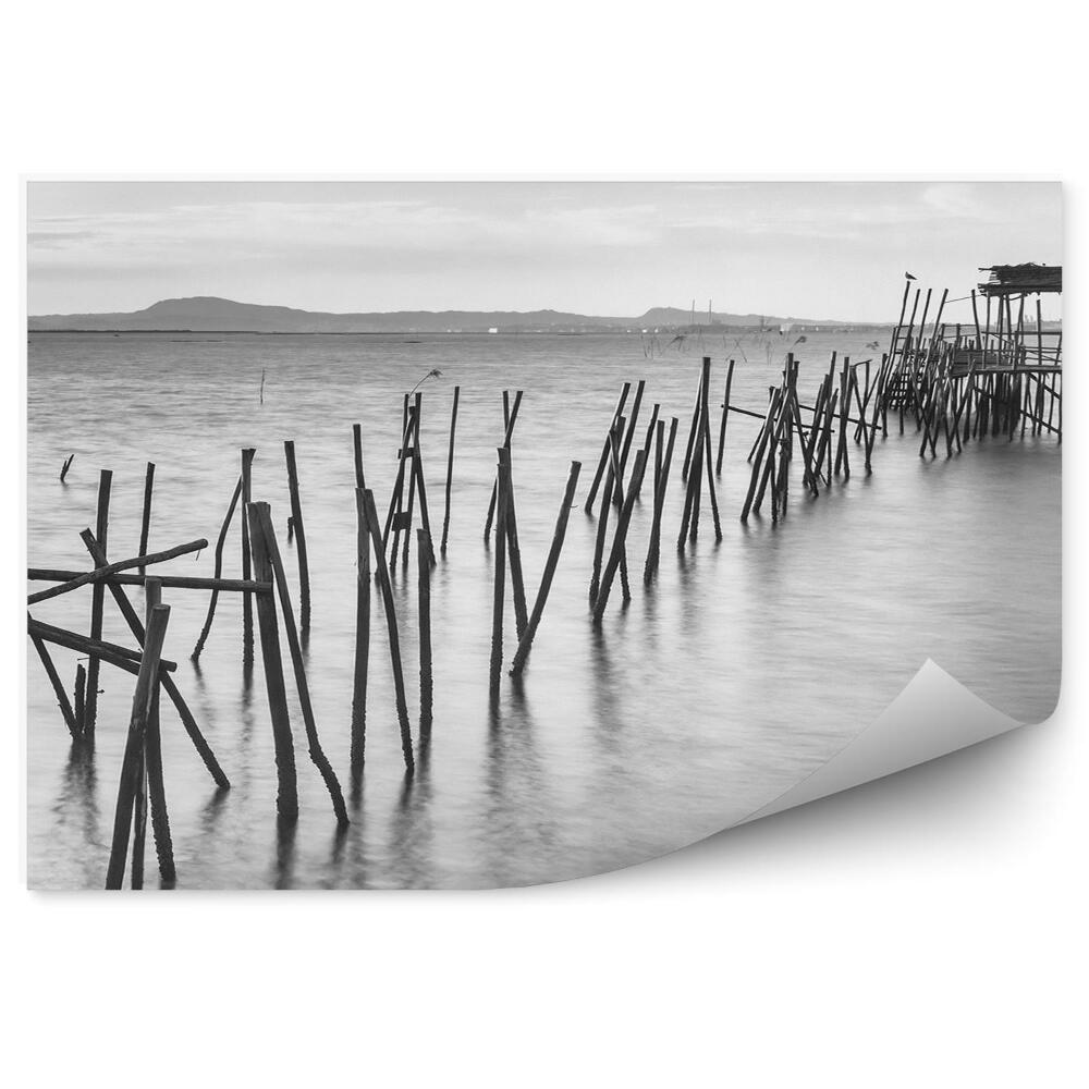 Fototapeta samoprzylepna Zniszczone drewniane molo morze czarno-białe zdjęcie
